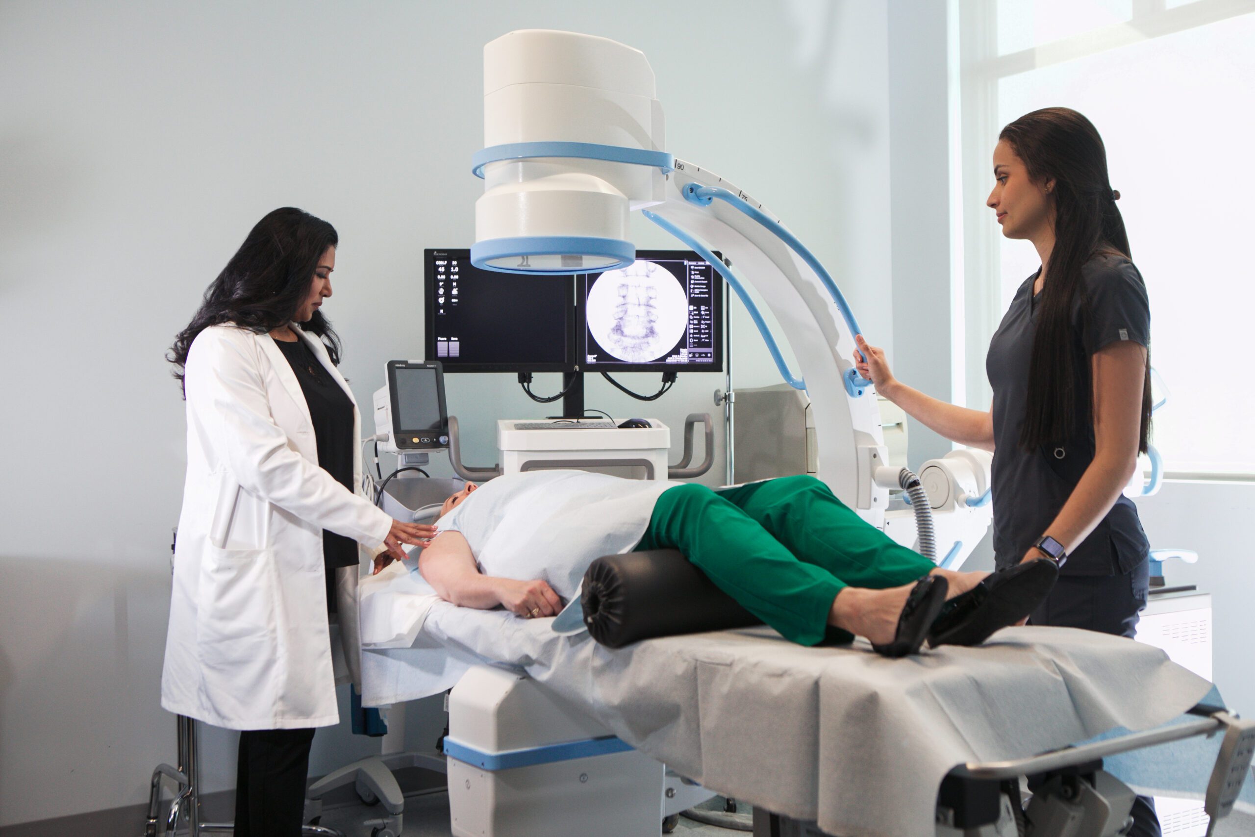 Medical team operating advanced imaging equipment with a patient